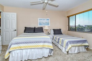 A bedroom with two beds, a ceiling fan, a window with blinds, and a framed picture on the wall. - Doveplum 621- Newly remodeled and refurnished 2BR/2.5BA townhome (Siesta Key)