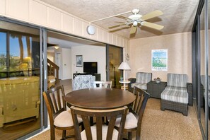 A dining area with a round table and chairs, a ceiling fan, and a view through a glass door. - Doveplum 621- 2 Story, 2 Bedroom Condo with Private Beach with lounge chairs & umbrella provided,... (Siesta Key)