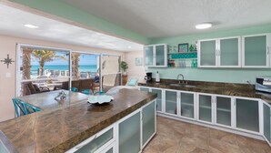 A kitchen with a large island, white cabinets, and a view of the beach. - Private Oasis On The Beach (Progreso)