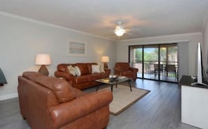 A living room with a sofa set, a coffee table, and a television.