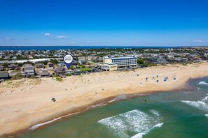 A coastal town with a beachfront hotel, sandy beach, and ocean views.
