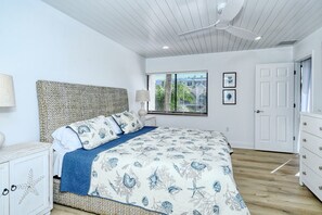 A bedroom with a bed, a nightstand, a dresser, a window with blinds, and a door. - Doveplum 112- 4 bedroom/3.5 bath beachfront townhouse ! (Siesta Key)