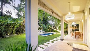 Un espacio al aire libre techado con piscina, una mesa de comedor y sillas.
