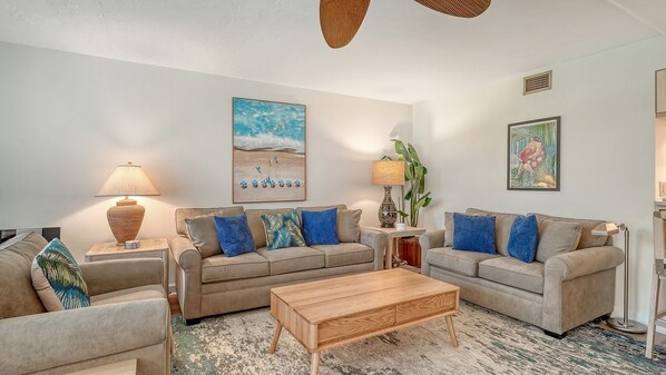 A living room with two sofas, a coffee table, and a rug.