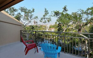 A balcony with two chairs, a railing, and a view of trees and buildings. - Doveplum 7224- 2BR canal-view townhouse in Sarasota with pool, WiFi, and private beach access. (Siesta Key)