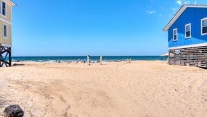 Une plage avec une tour de surveillance et un bâtiment bleu.