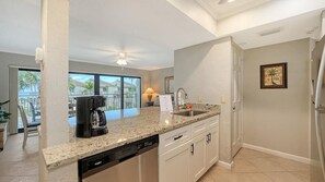 Eine Küche mit Granit Arbeitsplatte, Geschirrspüler und Kaffeemaschine.