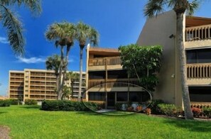 A hotel with a central courtyard, palm trees, and a building with balconies.