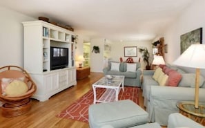 A living room with a television, sofa, and a coffee table.
