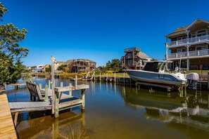 A marina with docked boats, wooden walkways, and waterfront buildings. - 433 Water-Front w/ Multi-Level Decking & Hot Tub (Nags Head)