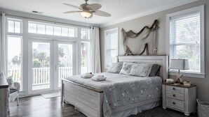 Un dormitorio con una cama, una mesita de noche, una lámpara y un ventilador de techo.