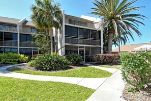 A modern building with a central courtyard, surrounded by palm trees and well-maintained landscaping. - Firethorn 510- 2 BR, 1.5 BA ground floor unit close to pool (Sarasota)