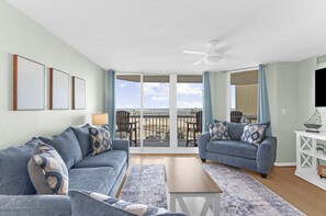 A living room with two sofas, a coffee table, and a TV stand.