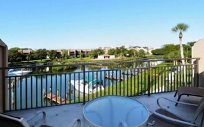 Ein Balkon mit Blick auf einen See, Boote und einen Swimmingpool.