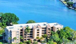 A multi-story hotel with a flat roof, located near a body of water.