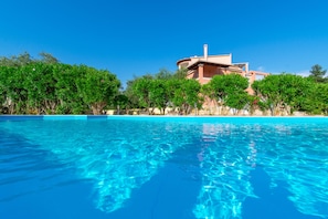 A clear blue pool with a building in the background. - Villa Rosa 2 , Dassia , Corfu (Corfu)