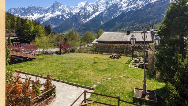 A mountain view with a grassy area, benches, and a lamp post. - Apt Beauregard1 Family Duplex Parking & near ski, Les Houches (Chamonix), France (Les Houches (Chamonix))