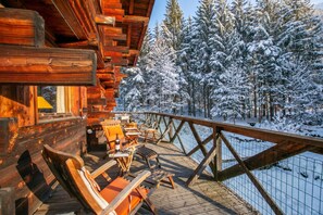 A wooden deck with outdoor seating, overlooking a snow-covered forest. - Chalet Tre la Vieux for 14 + Garden, Argentière (Chamonix), France (Argentière (Chamonix))