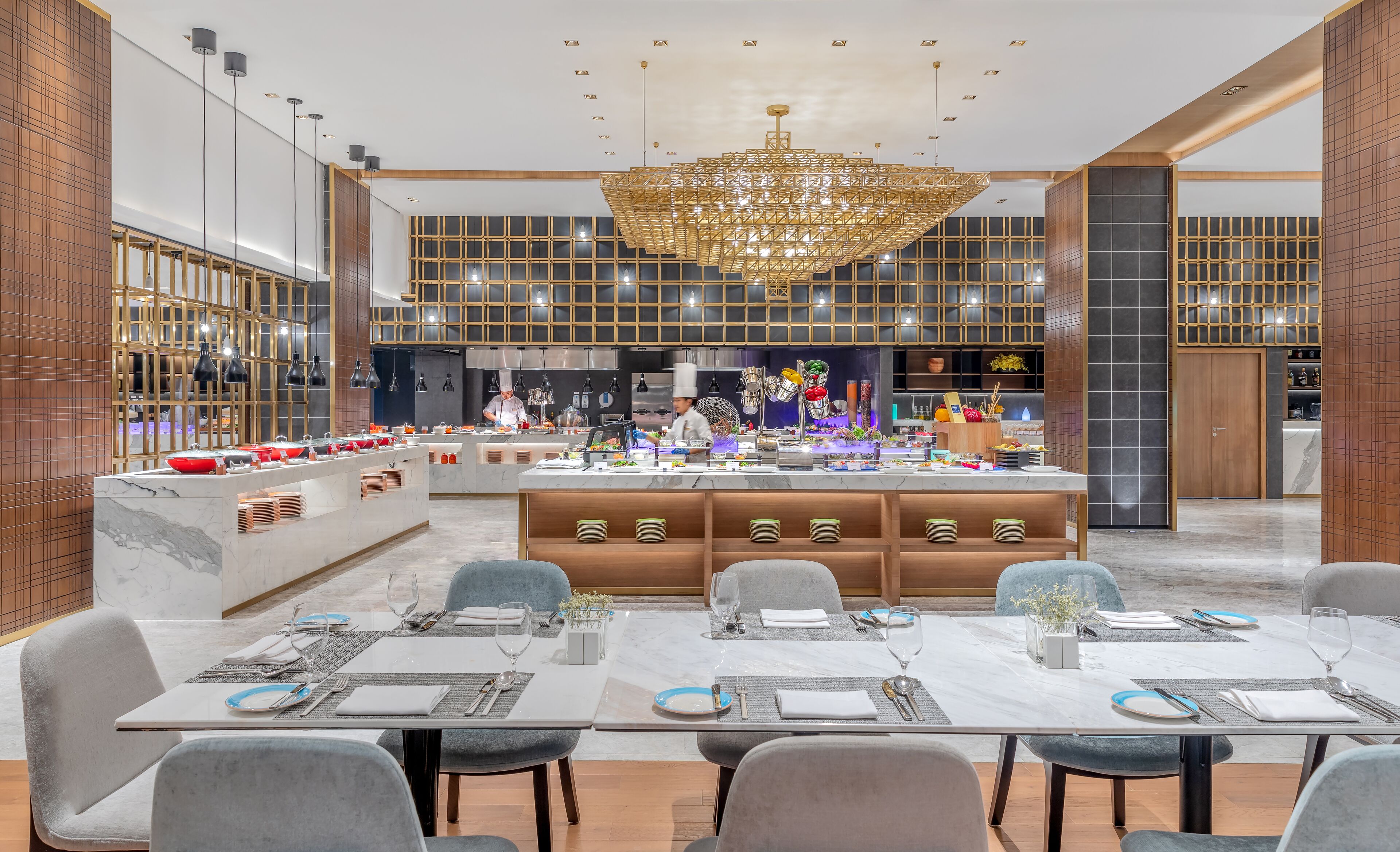 A modern dining area with a central island, multiple seating options, and a decorative chandelier.