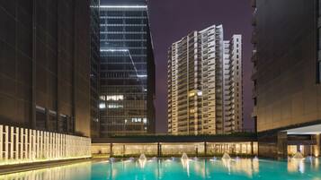 Una piscina al aire libre, sombrillas, sillones reclinables de piscina