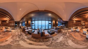 Un'ampia hall con soffitto a volta, una vasta area relax e vista sulla città.