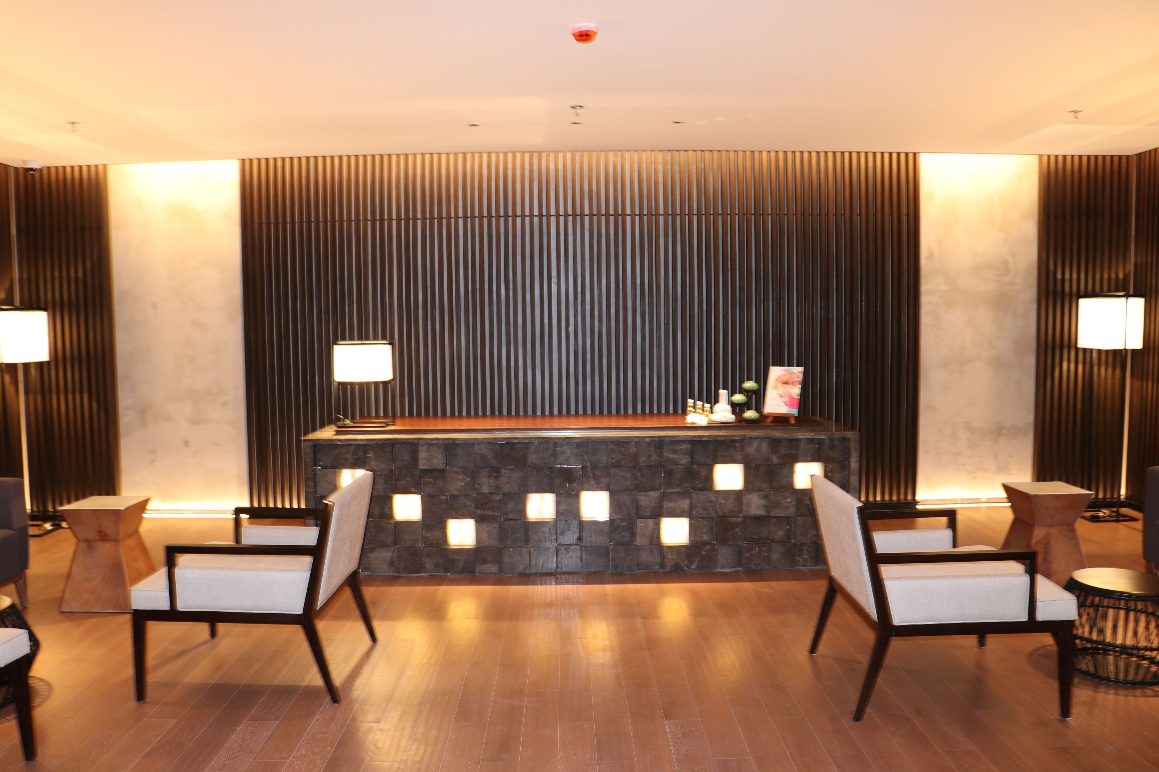 A reception area with a stone counter, two chairs, and a wooden floor.