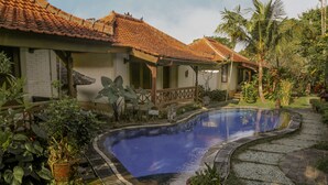 A house with a swimming pool, surrounded by lush greenery and a tiled roof. - Villa Chempaka (Ubud)