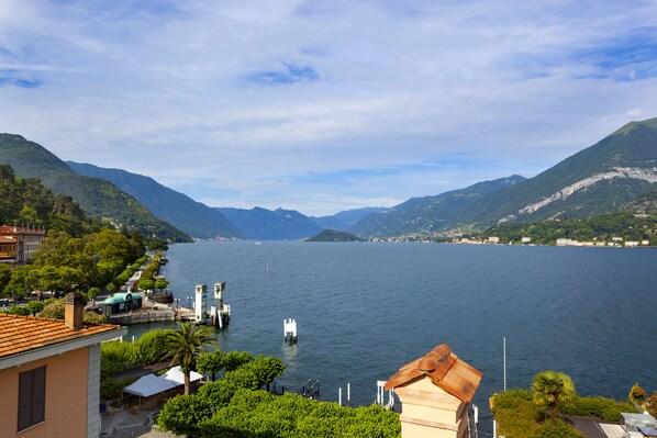 A lakeside view with mountains, buildings, and a dock.