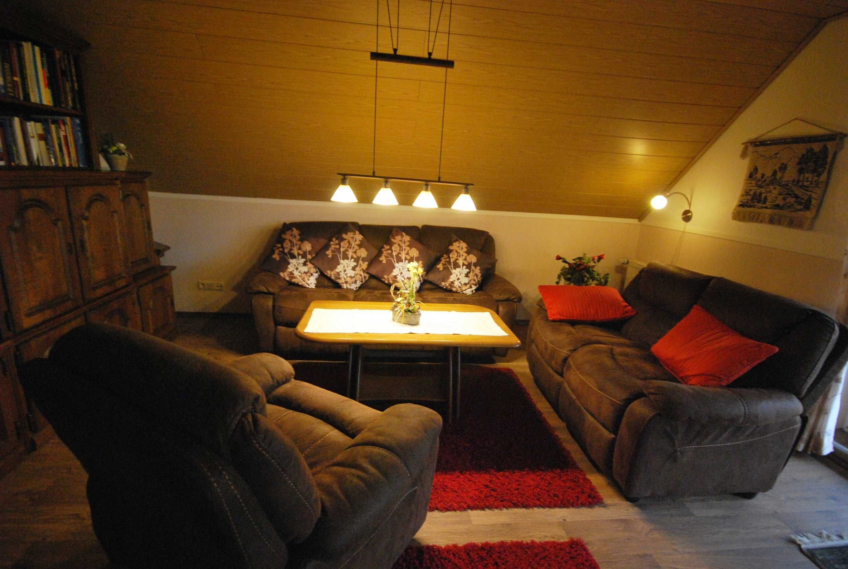Una sala de estar acogedora con un sofá, un sillón y una mesa de centro.