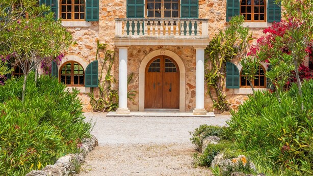 A stone building with arched windows and a central entrance.