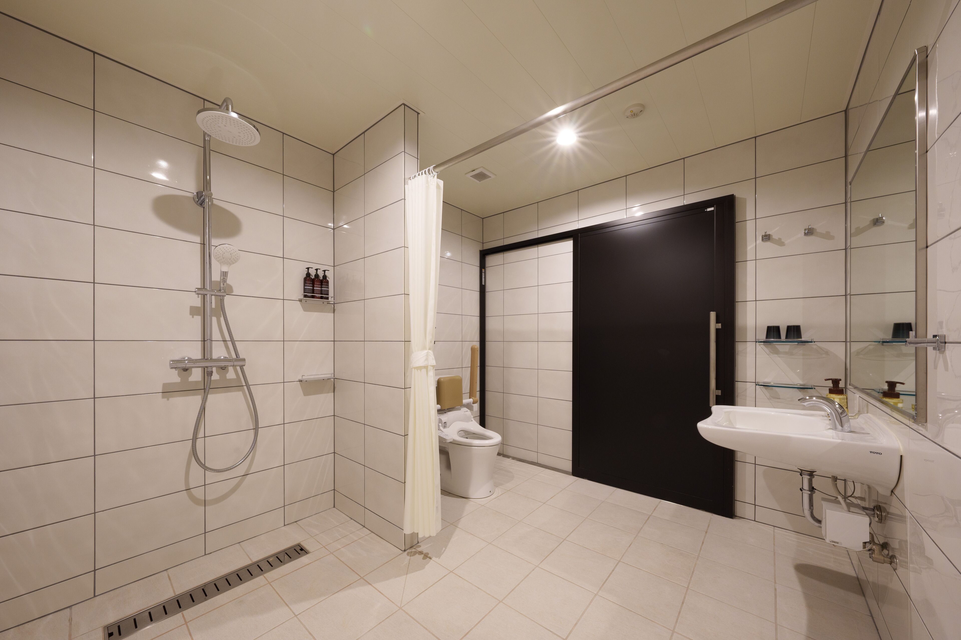 A modern bathroom with a shower, toilet, and sink.