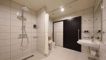 A modern bathroom with a shower, toilet, and sink.
