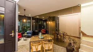 Un interior moderno con comedor, asientos y una escalera.