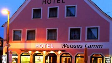 Vista frontal de la propiedad por la tarde o noche