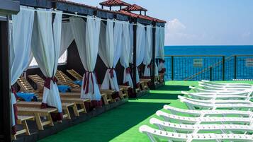 Nær stranden, solsenger, parasoller og strandhåndklær