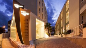 A modern hotel entrance with a curved sign listing amenities like a gym and restaurant. - Hotel & Residence Continental (Gabicce Mare)