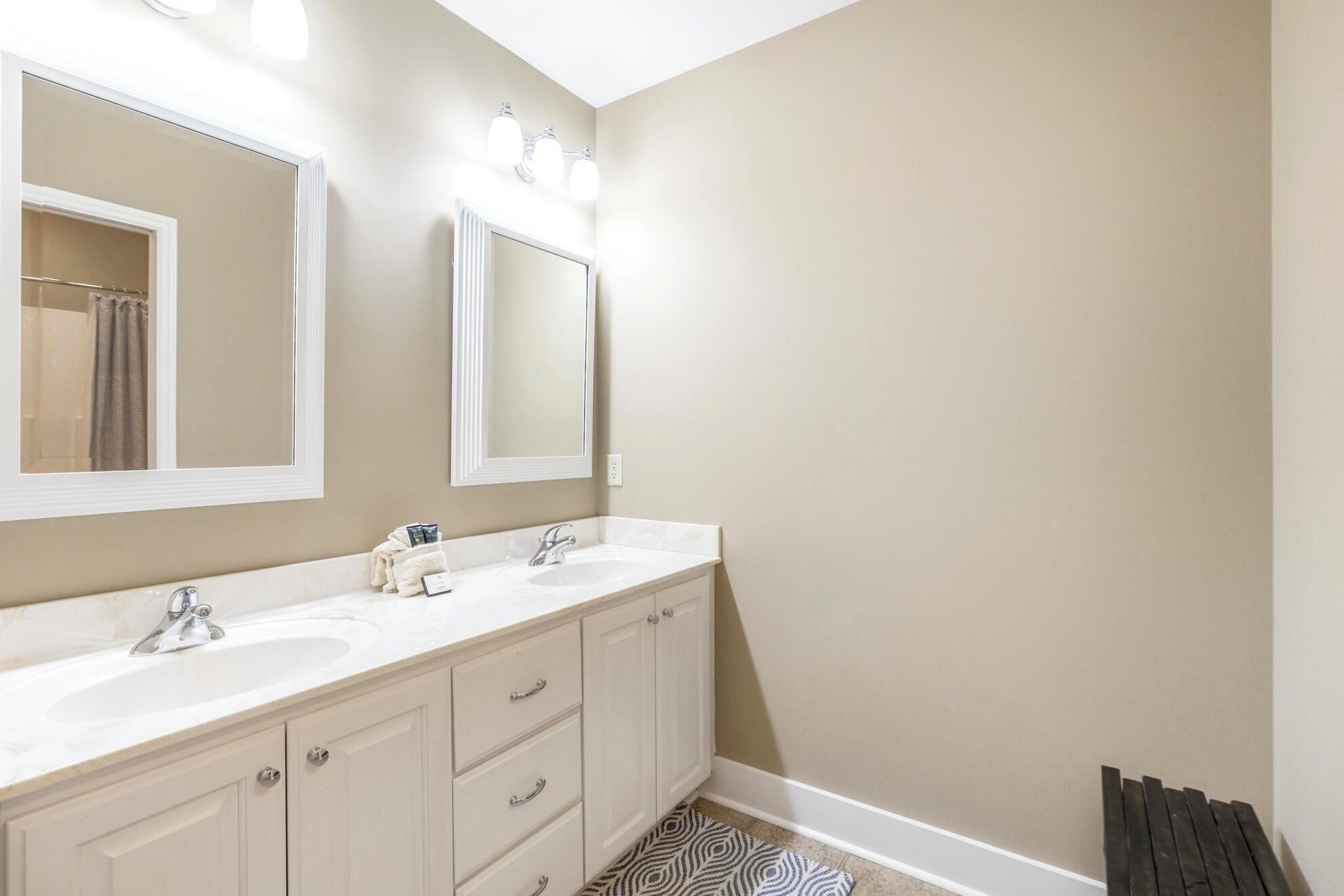 A bathroom with two sinks, a large mirror, and a towel rack.