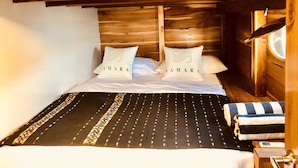 Une chambre à coucher de style cabane en bois, avec un lit, des oreillers et une fenêtre.