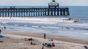 A pier extending into the ocean with a covered viewing area. - Stay @ Ocean's Nine on Folly Beach (Folly Beach)