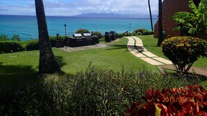 A well-maintained lawn with a barbecue area, a pathway, and a view of the ocean. - Kuleana 408 Ground Oceanfront - No Additional Owner Fees and Discounts Available (Lahaina)