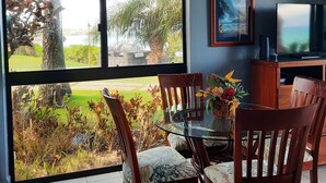 A dining area with a view of a garden and a mountain. - Kuleana 408 Ground Oceanfront - No Additional Owner Fees and Discounts Available (Lahaina)