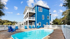 A two-story blue building with a swimming pool, white railings, and blue lounge chairs. - 2nd Row Oceanview, private pool, elevator, golf cart, and easy beach access. (Emerald Isle)