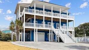 A two-story building with a balcony and a staircase leading to the upper level. - 2nd Row Oceanview, private pool, elevator, golf cart, and easy beach access. (Emerald Isle)