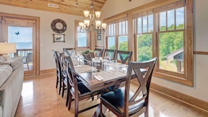 A dining area with a wooden table set for six, surrounded by chairs with cushioned seats. - Grand Oaks RS6- Mountain Condo, Gated Resort, Indoor/Outdoor Pools & Hot Tub (Banner Elk)
