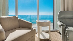 A room with a large window offering a view of the ocean, a beige sofa, a white side table, and a grey armchair. - Tower 2, 6th Floor Over Lagoon Pool! Best 3 Bedroom at Long Beach!! LAGOON POOL OPEN! (Panama City Beach)