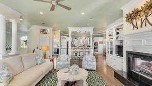 A spacious living room with a sofa, armchairs, a coffee table, and a fireplace. - Sandy Shanty: Luxurious Beach House with Rooftop Ocean Views! (Isle of Palms)