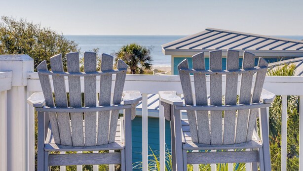 Two Adirondack chairs facing a pool and a view of the ocean. - Sandy Shanty: Luxurious Beach House with Rooftop Ocean Views! (Isle of Palms)