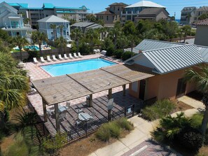 A pool area with lounge chairs and a covered seating area.