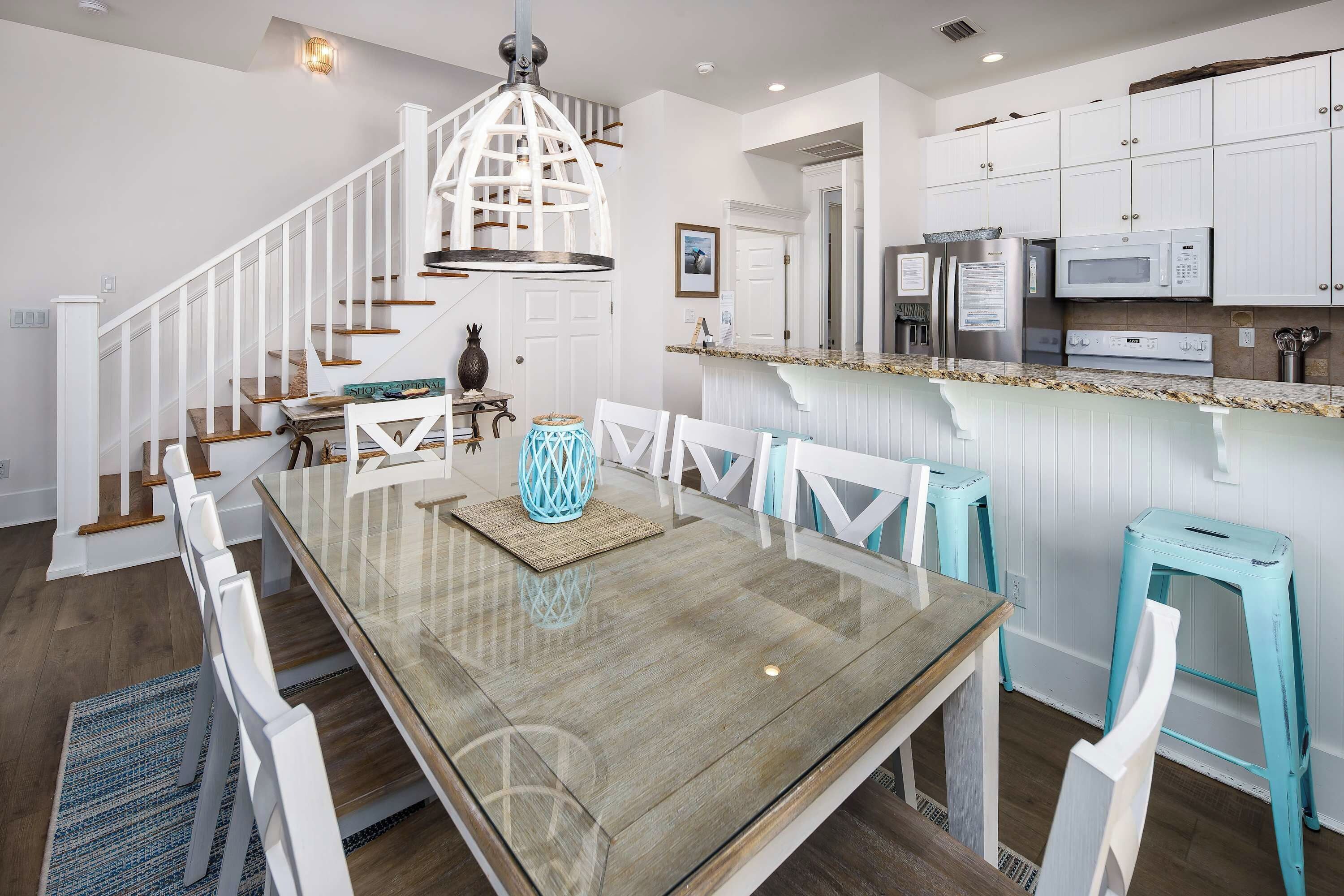 A modern kitchen with white cabinetry, a granite countertop, and stainless steel appliances.