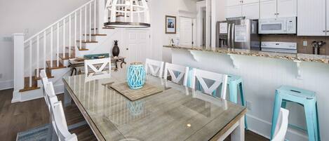 A modern kitchen with white cabinetry, a granite countertop, and stainless steel appliances.